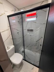 a bathroom with a toilet and a glass shower at Hotel Mustang in São Paulo +16 photos