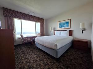 a hotel room with a bed and a desk and a window at Seagrass Oceanfront Inn in Newport +10 photos