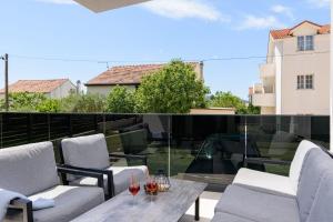 a patio with chairs and a table on a balcony at Rusulica Trogir in Seget Vranjica