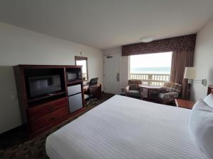 a hotel room with a bed and a flat screen tv at Seagrass Oceanfront Inn in Newport