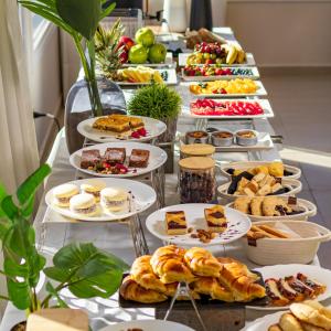ein langes Buffet mit Speisen auf einem Tisch in der Unterkunft Sul Mare Hotel in Valeria del Mar