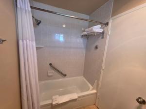 a bathroom with a tub and a shower with a shower curtain at Seagrass Oceanfront Inn in Newport