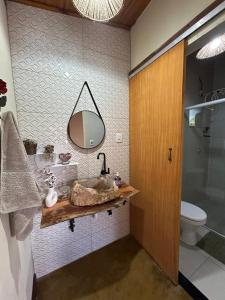 a bathroom with a sink and a mirror on the wall at Chalé da Janela in Lavras Novas