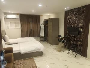 a hotel room with a bed and a television in it at company petty bark شركة بيتي بارك للشقق المخدومة درجة اقصادية in Qarār +6 photos