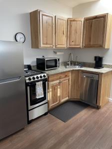 a kitchen with stainless steel appliances and wooden cabinets at The Cabin on Overland in Prescott