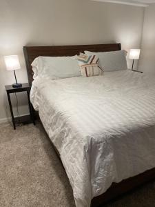 a bedroom with a large white bed with two lamps at The Cabin on Overland in Prescott