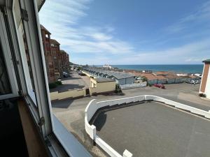 a view from a window of a street and the ocean at Flat White in Westward Ho
