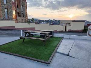 a picnic table sitting on a patch of green grass at Flat White in Westward Ho +2 photos