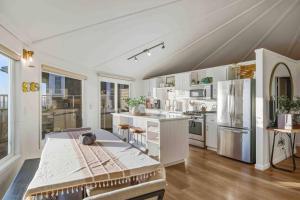 a large white kitchen with a table and a refrigerator at Boxer Bay in Tillamook