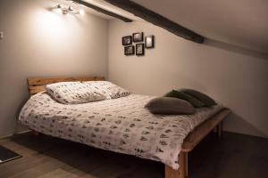 a bedroom with a bed with pillows on it at Appartements "La Chambre D'Ami" in Arles