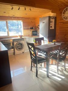 a kitchen with a table and chairs in a room at Domek Zacisze całoroczny in Świętne