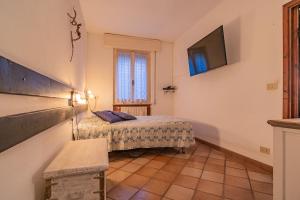 a small bedroom with a bed and a television at Villa la Paolina in Marciana