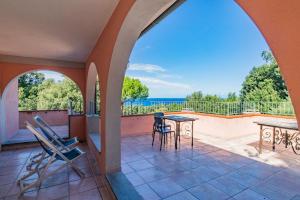 a patio with a table and chairs and the ocean at Villa la Paolina in Marciana