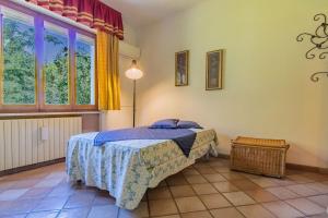 a bedroom with a bed and a large window at Villa la Paolina in Marciana