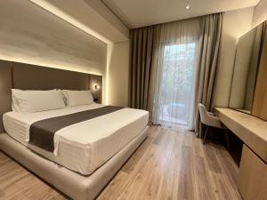 a bedroom with a large bed and a window at Riviera Boutique Hotel by Pomo d'oro in Vlorë