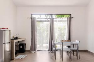 a kitchen with a table and chairs and a large window at Casa Paula in Liberia