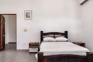 a bedroom with a large bed with a wooden headboard at Casa Paula in Liberia