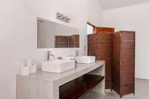 a bathroom with two sinks and a mirror at Casa Paula in Liberia