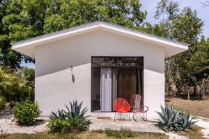 two chairs in front of a small white house at Casa Paula in Liberia