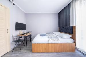 a bedroom with a bed and a desk and a tv at Meryem Ana House in Mardin