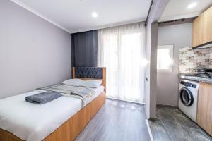 a small bedroom with a bed and a washing machine at Meryem Ana House in Mardin