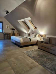 a bedroom with a king sized bed and a couch at VILLA LIPOVA STEGNA pokoje i apartamenty dedykowane osobom dorosłym in Stegna