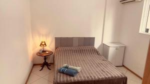 a bedroom with two beds and a table with a lamp at Apartamento perto do HCAA - com Garagem in Santa Maria