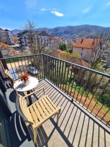a balcony with a table and two chairs and a view at Lasta Apartman Sokobanja in Soko Banja