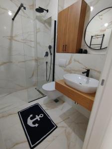 a bathroom with a shower and a sink and a toilet at Kanber Inn in Budva