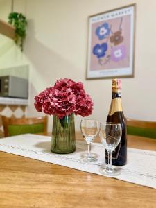 a bottle of champagne and flowers and glasses on a table at Kanber Inn in Budva