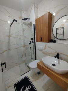 a bathroom with a shower and a toilet and a sink at Kanber Inn in Budva