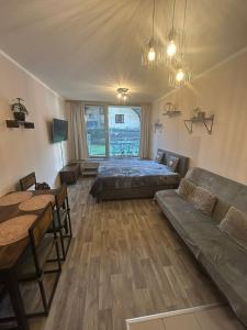a bedroom with a bed and a couch and a table at Apartmán Míša in Harrachov