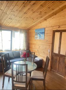 a living room with a table and a couch at Zacisze 6 osobowy Domek nad jeziorem in Świętne