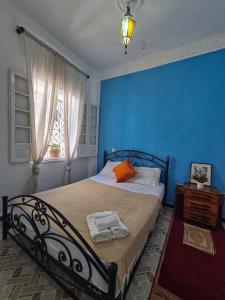 a blue bedroom with a bed with towels on it at La Joya Hostel Chafchaouen Cozy Stay with Terrace in Chefchaouen +46 photos