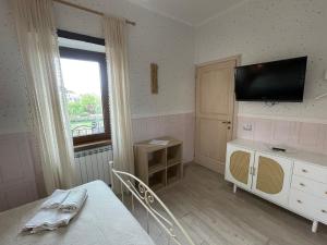 a bedroom with a bed and a television on the wall at Historic family house in Montefiascone