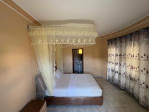 a bedroom with a bed with a canopy at Wilna Motel Garuga in Kagolomolo