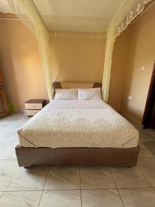 a bedroom with a bed with a canopy at Wilna Motel Garuga in Kagolomolo