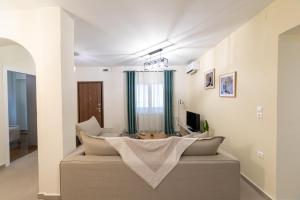 ein Wohnzimmer mit Sofa und Fernseher in der Unterkunft Kariatides in Sparta