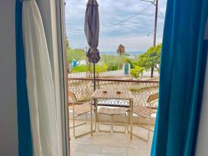 a table and chairs on a balcony with an umbrella at Sea View Chic Apartment in Karianí