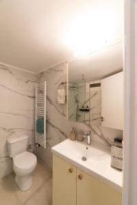 ein weißes Badezimmer mit Toilette und Waschbecken in der Unterkunft Kariatides in Sparta + 24 Fotos