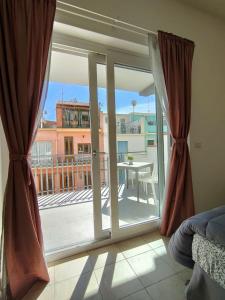 a room with a sliding glass door with a view of a balcony at M&C Home in Letojanni