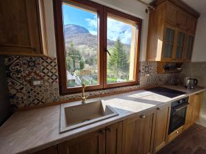 a kitchen with a sink and a large window at Ethno Village Štitarica in Mojkovac +71 photos