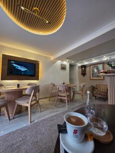a cup of coffee on a table in a lobby at Hotel Mažijanik in Nikšić