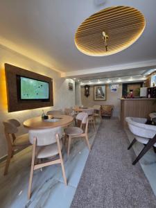a restaurant with tables and chairs and a tv on the wall at Hotel Mažijanik in Nikšić