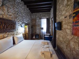 a bedroom with a bed in a stone wall at Casa Alegre Alaçatı in Alaçatı