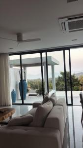 a living room with a couch and a large window at 030vollsamui in Ban Bang Po