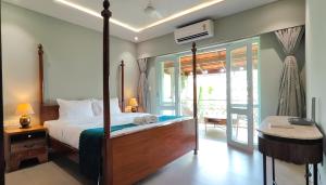 a bedroom with a large bed and a balcony at Plot 77 by hnh in Baga