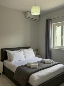 a bedroom with a large bed with two towels on it at Lūm Posidonia in Posidhonía