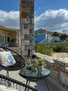 a table with wine glasses on a patio at Lūm Posidonia in Posidhonía