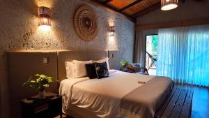 a bedroom with a bed with white sheets and a window at Pousada Aldeia da Serra in Palmas +36 photos